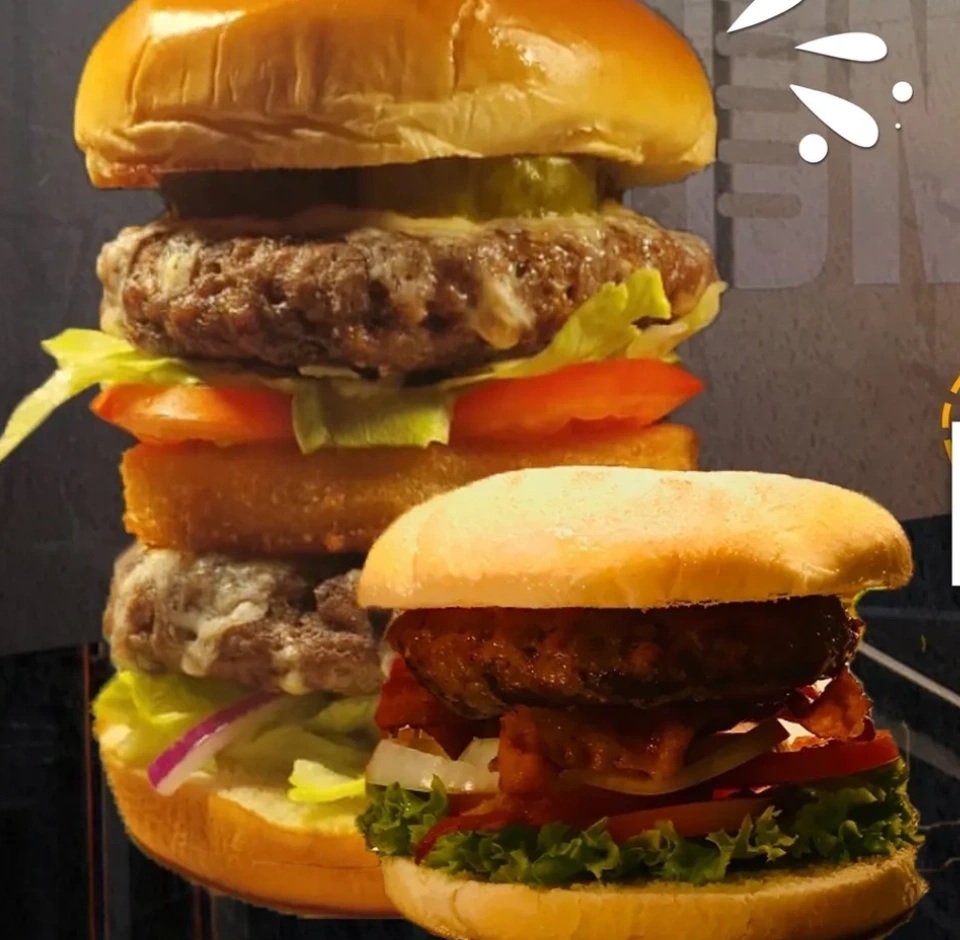 Stacked burgers with lettuce, tomato and onion on brioche buns